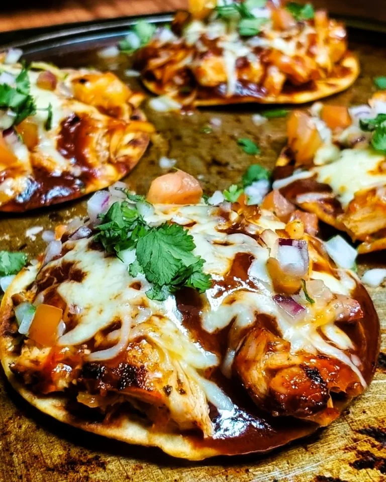 Plate of BBQ chicken tostadas topped with fresh ingredients and garnished.