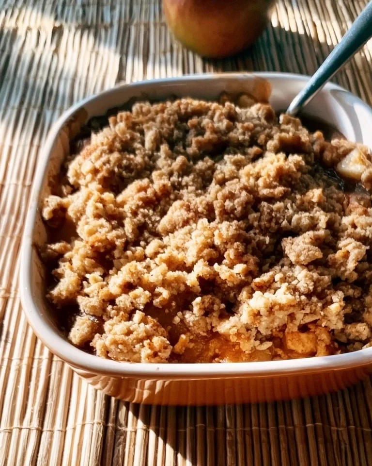 Gluten-free apple crisp served in a bowl with a scoop of vanilla ice cream