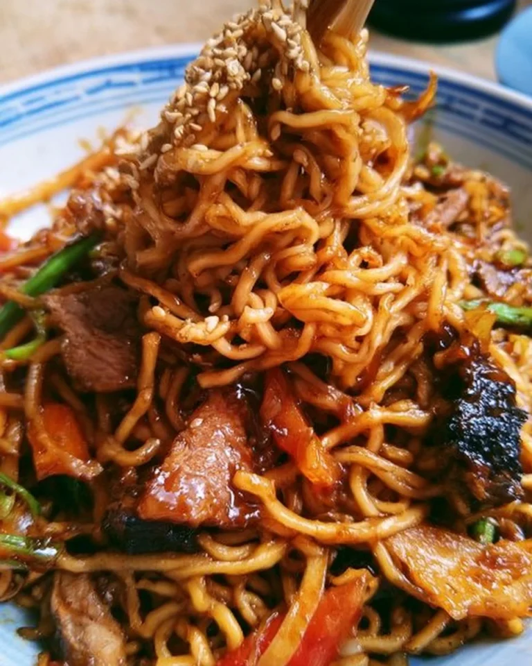 Stir-Fry Japanese BBQ Ramen Noodles dish garnished with fresh vegetables.