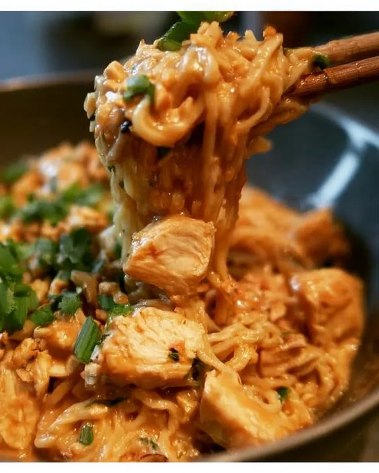 A bowl of Thai Peanut Sauce Ramen with chicken, garnished with vegetables.